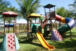 a playground with different types of slides on the grass at Aquaville Aquiraz Hotel in Aquiraz