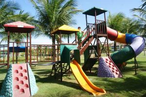 um parque infantil com diferentes tipos de escorregas na relva em Aquaville Resort em Aquiraz