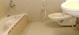 a bathroom with a sink and a toilet and a tub at Ksr woodland Residency in Kodaikānāl