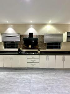 une cuisine avec des armoires blanches et un comptoir noir dans l'établissement Mega Villa 5 Bedroom Stand Alone Duplex, à Ikuata 15 autres photos