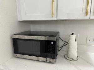 a microwave on a counter with a roll of paper towels at Modern 3BR in Bishop Arts Walk to Shops in Dallas +18 photos