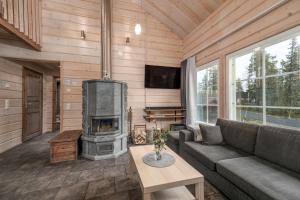 un salon avec cheminée dans une cabane en rondins dans l'établissement Ylläksen Taiga, à Ylläsjärvi