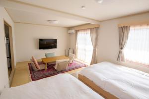 a bedroom with a bed and a table and chairs at Guesthouse Life Field in Kurashiki