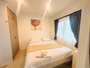 Phuket naka Condon-41无边泳池免费上网免费停车位 في فوكيت تاون: غرفة نوم صغيرة بها سرير ونافذة +92 صورة