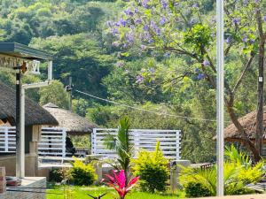 a view of a garden with white benches at Siyaya’s Guest Palace in Jozini