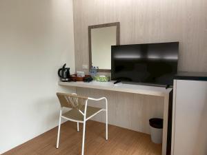 een kamer met een stoel en een flatscreen-tv bij Salty Sand Krabi Hotel in Ban Khlong Haeng +17 foto's