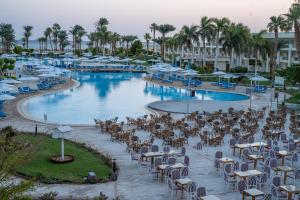 a pool with chairs and umbrellas in a resort at JAZ Royal Palmariva in Hurghada