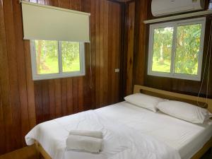 a bedroom with a bed with two pillows and a window at Baan Phuean Koh Kood in Ko Kood
