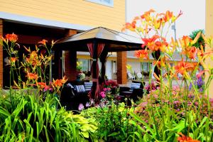 a garden with an umbrella in front of a house at Motel Centre-Ville in Montmagny