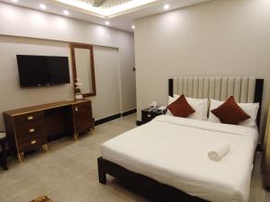 Blue Sky Hotel Clifton 2 في كراتشي: غرفة فندق بها سرير وتلفزيون +12 صورة