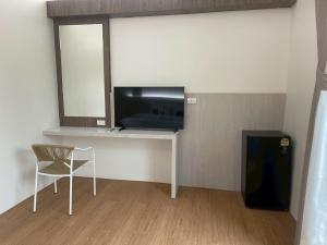 a room with a desk with a television and a chair at Salty Sand Krabi Hotel in Ban Khlong Haeng