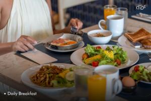 a table with plates of food on it at Hotel Tide Phuket Beachfront in Phuket Town