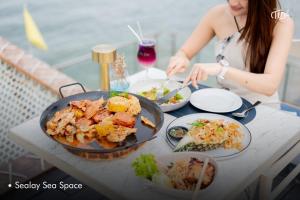 a woman sitting at a table with a plate of food at Hotel Tide Phuket Beachfront in Phuket Town +94 photos