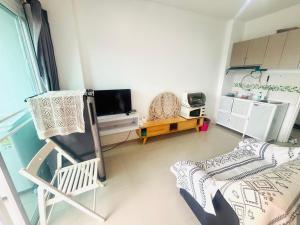 Phuket naka Condon-41无边泳池免费上网免费停车位 في فوكيت تاون: غرفة معيشة مع كرسي وتلفزيون