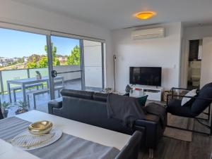 a living room with a couch and a television at Modern & Relaxed Apartment, Great Views @Wright in Weston Creek