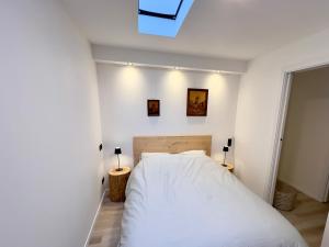BischoffsheimにあるPetite maison indépendante avec garage attenantのベッドルーム(白いベッド1台、ランプ2つ付)