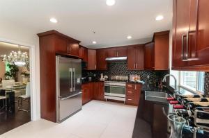 Una cocina con gabinetes de madera y un refrigerador de acero inoxidable. en W 20 House, en Vancouver 6 fotos más