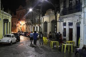 a group of people walking down a street at night at Stella Cama e Cafe in Salvador