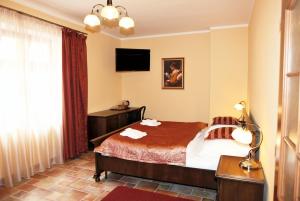 a hotel room with a bed and a television at Hotel Pelikán in Třeboň