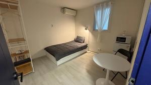 a small bedroom with a bed and a table at SRR Stay in Gwangmyeong