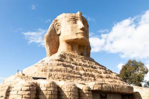 uma estátua de uma cabeça no topo de um edifício em Sphinx Hotel em Hamlyn Heights