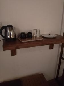 a wooden shelf with a tea kettle and glasses on it at Solace Transit Villa in Katunayake
