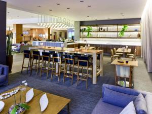 a restaurant with tables and chairs and a bar at Novotel Sao Paulo Center Norte in Sao Paulo