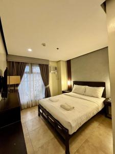 a bedroom with a large bed and a large window at kasa Boutique Hotel Capitol in Cebu City