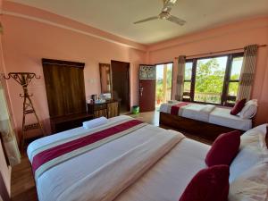 um quarto de hotel com duas camas e uma janela em Hotel Tree Tops- A Serene Friendly Hotel in Sauraha em Chitwan