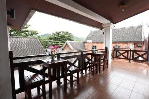 a patio with a table and chairs on a balcony at We House River View Hotel And Travel in Luang Prabang