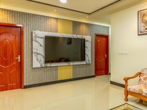 a living room with a flat screen tv on a wall at Villaasa in Shaviyani Atoll