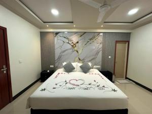 a bedroom with a large bed with a painting on the wall at Villaasa in Shaviyani Atoll