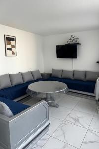 a living room with a blue couch and a table at Appartement t3 à Montpellier in Montpellier