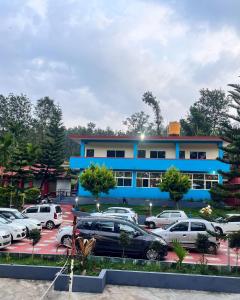 a parking lot with cars parked in front of a building at Saatvik Stay 2 - A Dormitory Stay in Kushālnagar