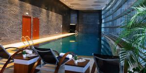 a swimming pool with two chairs and a table and a pool at InterContinental Nanjing by IHG in Nanjing