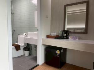 een badkamer met een wastafel en een spiegel bij Salty Sand Krabi Hotel in Ban Khlong Haeng