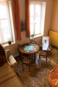 a living room with a table and chairs and windows at Apartament Hamak in Sopot