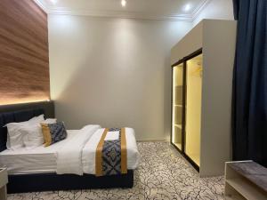 ein Schlafzimmer mit einem Bett und einem Schrank in der Unterkunft ايفان شقق المخدومة العوالي in Quai + 10 Fotos