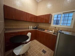 eine kleine Küche mit einem Tisch und Stühlen darin in der Unterkunft ايفان شقق المخدومة العوالي in Quai