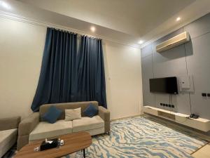 ein Wohnzimmer mit Couch und Flachbildfernseher in der Unterkunft ايفان شقق المخدومة العوالي in Quai