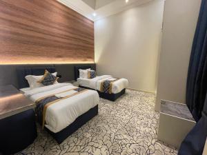 ein Hotelzimmer mit zwei Betten in einem Zimmer in der Unterkunft ايفان شقق المخدومة العوالي in Quai