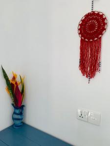 Un jarrón con flores junto a una pared. en Hidden Well Hiriketiya, en Hiriketiya