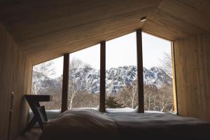 a bed in a room with a large window at Earthboat Togakushi in Nagano +63 photos