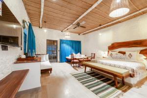a bedroom with a bed and a table and chairs at Dunes & You - A Desert Retreat in Govindgarh