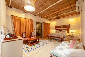 a living room with a bed and a couch at Dunes & You - A Desert Retreat in Govindgarh