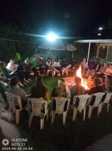 a group of people sitting around a fire at night at Homebase gardens homestay in Nakuru