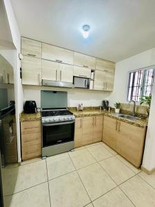 eine Küche mit Holzschränken und einem Herd in der Unterkunft Casa completa en fraccionamiento privado San Jerónimo Coatepec in Coatepec