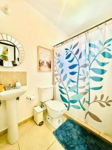 ein Badezimmer mit Toilette, Waschbecken und Duschvorhang in der Unterkunft Casa completa en fraccionamiento privado San Jerónimo Coatepec in Coatepec