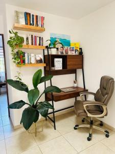 ein Schreibtisch und ein Stuhl und eine Pflanze in einem Zimmer in der Unterkunft Casa completa en fraccionamiento privado San Jerónimo Coatepec in Coatepec