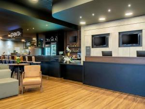 ein Restaurant mit einer Bar mit Tischen und Stühlen in der Unterkunft ibis Piracicaba in Piracicaba